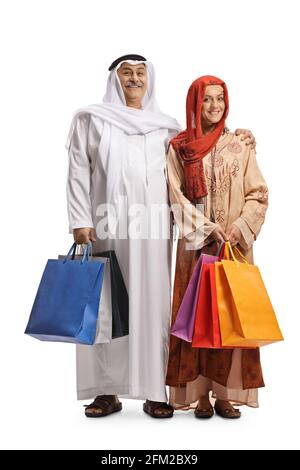 Portrait complet d'un homme arabe mûr et d'un jeune femme musulmane tenant des sacs de shopping isolée sur fond blanc Banque D'Images