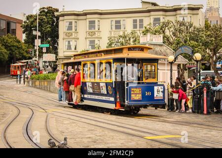 San Francisco, Californie / Etats-Unis d'Amérique - 27 mai 2013: Personnes voyageant sur le téléphérique jaune et bleu nostalgique de Friedel Klussmann Banque D'Images