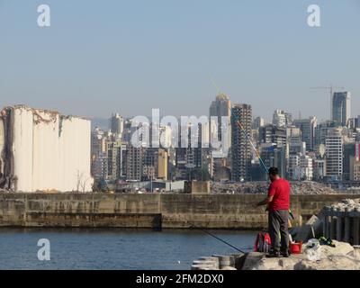 Beyrouth, Liban. 25 avril 2021. Hommes pêchant dans le port de Beyrouth, Liban, le 25 avril 2021.en arrière-plan, les silos endommagés par Beyrouth Blast le 4 août 2020. (Photo d'Elisa Gestri/Sipa USA) crédit: SIPA USA/Alay Live News Banque D'Images