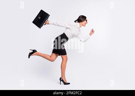 Pleine photo de profil de la brunette optimiste cheveux dame courir portez des lunettes jupe-chemise isolée sur fond gris Banque D'Images