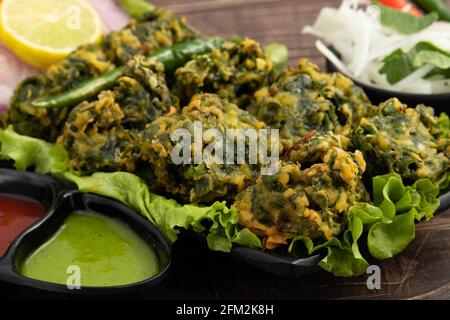 Collations croustillantes au Chaat indien Palak Pakoda Bhajji Chat ou Paalak Pakora Bajji Bhajiya riche en fibres vitamine minérale et protéine Est fait de Spinac haché Banque D'Images