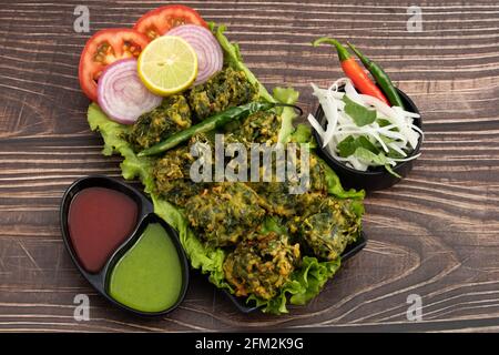 Indian Street Food Palak Pakoda Bhajji Chat ou Paalak Papora Bajji Bhajiya riche en fibres vitamine minérale et protéine est Fait de Dhaniy d'épinards hachés Banque D'Images