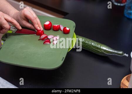 Vue rapprochée du radis féminin pour salade verte. Concept de saine alimentation. Suède. Banque D'Images