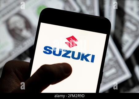Sur cette photo, le logo Suzuki du constructeur automobile multinational japonais est affiché sur un smartphone avec une devise en dollars américains (USD) en arrière-plan. (Photo de Budrul Chukrut / SOPA Images/Sipa USA) Banque D'Images