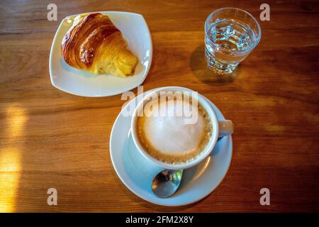 Café avec lait (latte) et croissant au beurre. Banque D'Images