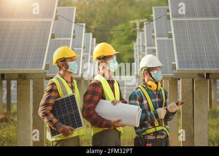 Trois ingénieurs travaillant dans une station solaire, Thaïlande Banque D'Images