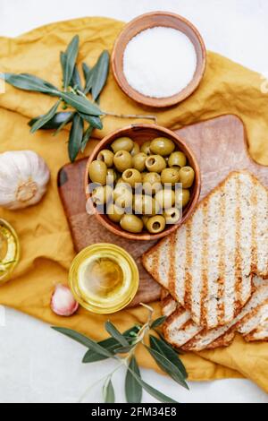 Vue panoramique sur des tranches de toast ciabatta aux olives vertes, à l'huile d'olive et à l'ail frais Banque D'Images