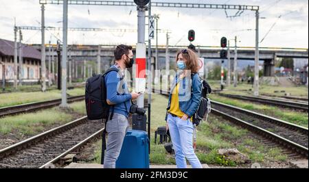 couple portant un masque à la gare Banque D'Images