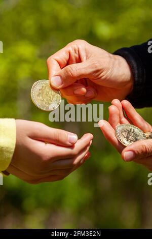 Un enfant demande de l'argent de poche et son parent donne une pièce de bitcoin en réponse. Image de concept dans le paramètre de famille pour l'utilisation de crypto-monnaie dans d Banque D'Images