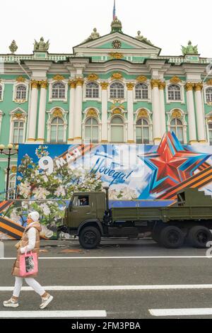 Un énorme panneau d'affichage en tissu et du matériel militaire en face du Palais d'hiver à Saint-Pétersbourg, en Russie, lors de la célébration du jour de la victoire Banque D'Images