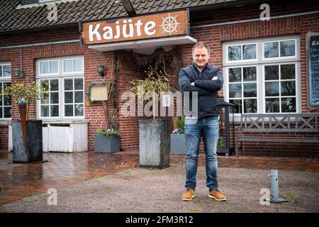 Horumersiel, Allemagne. 05e mai 2021. Mario Krar, opérateur d'hôtel et de restaurant, se trouve en face du restaurant. A partir de lundi, des séjours touristiques de nuit en Basse-Saxe en dehors des points chauds de Corona seront à nouveau possibles, pour le moment seulement pour les propres habitants. Ils pourront ensuite effectuer de nouveau des formalités d'enregistrement dans les hôtels, les appartements de vacances et les campings, ainsi que des tests rapides négatifs ou des preuves de vaccination. Credit: Sina Schuldt/dpa/Alay Live News Banque D'Images