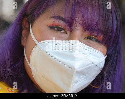 Une jeune femme indigène sud-américaine, avec un beau maquillage pour les yeux et des cheveux teints en bleu, porte un masque KN95 pendant la pandémie du coronavirus. Banque D'Images