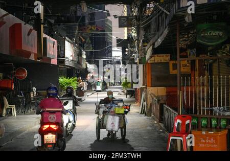 Bangkok, Thaïlande. 05e mai 2021. Une femme pousse son chariot alimentaire le long de la célèbre rue de divertissement de bar de Go de Soi Cowboy. Les lieux de divertissement nocturne de Bangkok, les bars, les pubs et les restaurants sont fermés dans la zone rouge désignée. Un verrouillage partiel a été imposé pendant 2 semaines entre le 3 et le 17 mai 2021, en raison d'une récente augmentation de l'épidémie du virus Covid C-19 dans la capitale. (Photo de Paul Lakatos/SOPA Images/Sipa USA) crédit: SIPA USA/Alay Live News Banque D'Images