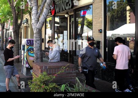 San Mateo, États-Unis. 5 mai 2021. Les gens marchent devant un restaurant dans la ville de San Mateo, Californie, États-Unis, 5 mai 2021. Le comté de San Mateo, où se trouve la ville de San Mateo, se trouve actuellement au niveau orange le moins restrictif du contrôle COVID-19. Crédit : Wu Xiaoling/Xinhua/Alay Live News Banque D'Images