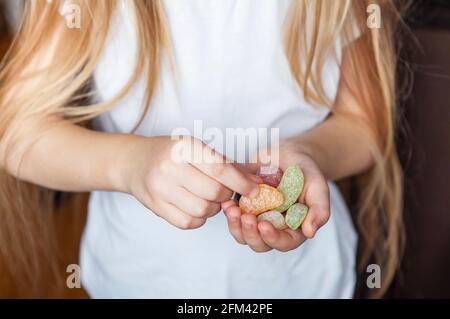 Petite fille tenant des bonbons doux dans ses mains Banque D'Images