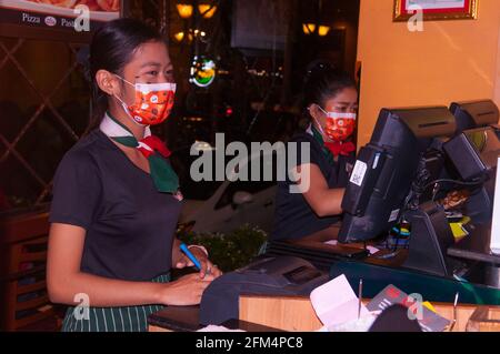 Une hôtesse et une caissière cambodgiennes attirantes portent des masques protecteurs élégants en raison de la pandémie COVID -19 pendant Halloween, qui a également coïncidé avec le festival de l'eau cette année. 30 octobre 2020. Phnom Penh, Cambodge. © Kraig Lieb Banque D'Images