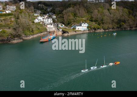 Une série de dinghies est remorquée sur la rivière Fowey à la traversée de Bodinnick Ferry entre Fowey et Polruan, Cornwall, Royaume-Uni Banque D'Images