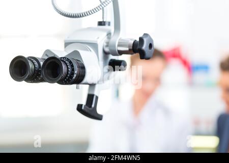 - Jeune femme médecin consultant ou spécialiste en ORL - avec un patient dans sa pratique, au premier plan sont des outils médicaux Banque D'Images