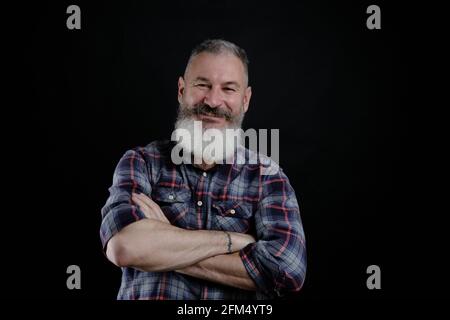 Portrait d'un beau homme mature barbu isolé sur fond noir, homme caucasien avec la barbe souriante Banque D'Images