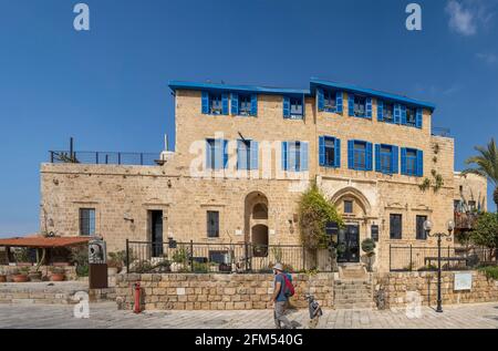 Jaffa, Israël - 31 mars 2021 : une ancienne maison en pierre, avec des volets bleu méditerranéen typiques, située dans la vieille ville de Jaffa, Israël. Banque D'Images