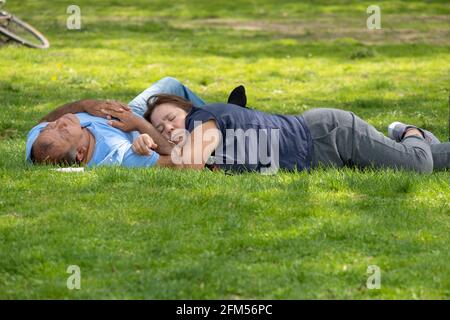 Un couple, probablement mari et femme, prenez une sieste l'après-midi dans le parc Flushing Meadows Corona à Queens, New York City. Banque D'Images