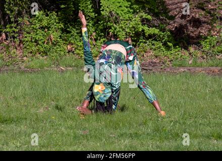 Une femme agile dans ses années 50 à un cours de yoga méditatif dans un parc à Flushing, Queens, New York City. Banque D'Images