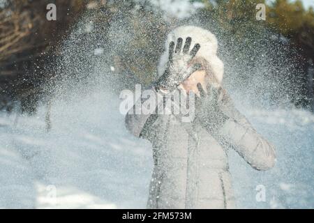 Joyeux hiver. Une femme joue dehors en chute de neige en appréciant les flocons de neige qui tombent. Temps froid en extérieur, mise au point sélective. Banque D'Images