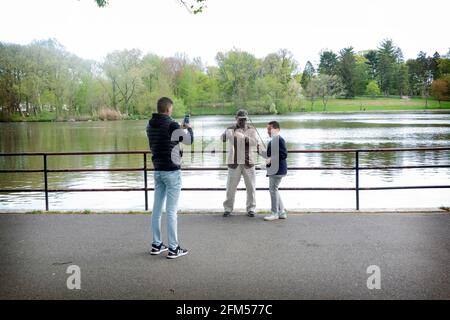 Un jeune garçon fier pose avec sa famille montrant le poisson qu'il a attrapé. Au lac de Kissena Park, Flushing, Queens, New York City. Banque D'Images