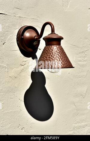 Une lampe en cuivre qui jette une ombre sombre. Banque D'Images