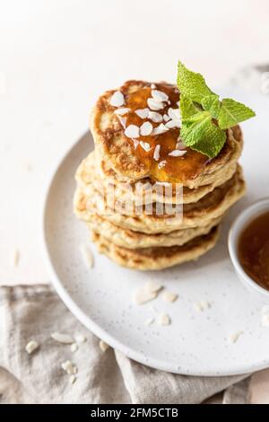 Crêpes d'avoine saines avec confiture, noix et menthe sur plaque en céramique. Repas de petit-déjeuner végétalien. Mise au point sélective. Banque D'Images