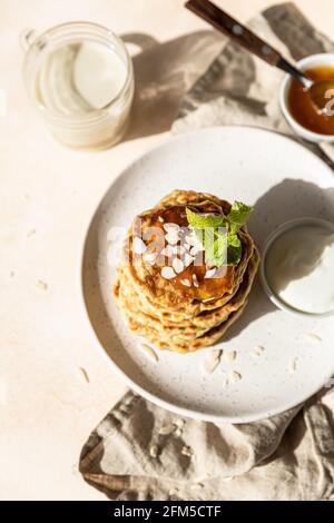 Crêpes d'avoine saines avec confiture, noix et menthe sur plaque en céramique. Repas de petit-déjeuner végétalien. Mise au point sélective. Banque D'Images