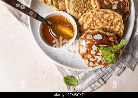 Crêpes d'avoine saines avec confiture, noix et menthe sur plaque en céramique. Repas de petit-déjeuner végétalien. Mise au point sélective. Banque D'Images