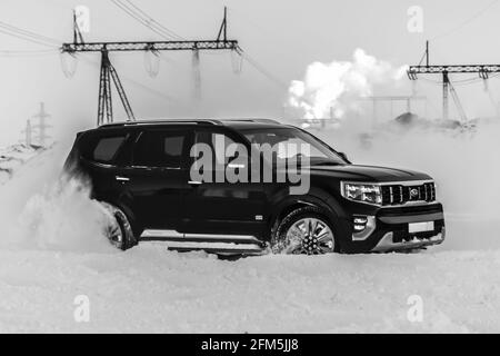 Moscou, Russie - 15 février 2021 : le Kia Mohait 2021 se dresse en 4x4 noir sur la route en forêt d'hiver, déneigeuses. Vue latérale Banque D'Images