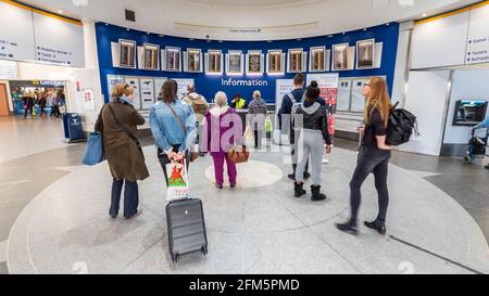 Bureau d'information de la gare routière victorienne de Londres. Les voyageurs arrivant et parcourant les panneaux de départ du plus grand terminal de bus de Londres. Banque D'Images