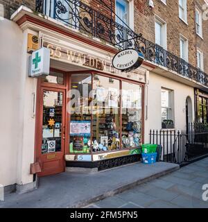 Magasin de chimistes anglais traditionnel. La fenêtre et la façade d'un petit magasin d'affaires de Londres dans les rues de Kensington et Chelsea. Banque D'Images