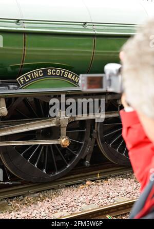 Un spectateur vidéoludique célèbre locomotive à vapeur Flying Scotsman, lors d'une journée humide à Salisbury.21.05.2016. Banque D'Images