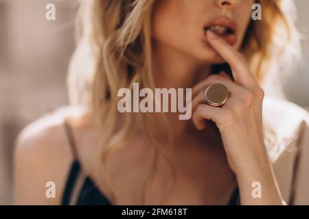 Portrait artistique défoqué d'une belle femme blonde à travers le verre en teinte beige. Hors foyer Banque D'Images