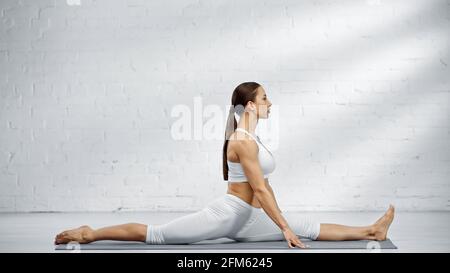 Une jeune femme se fende sur un tapis de yoga Banque D'Images