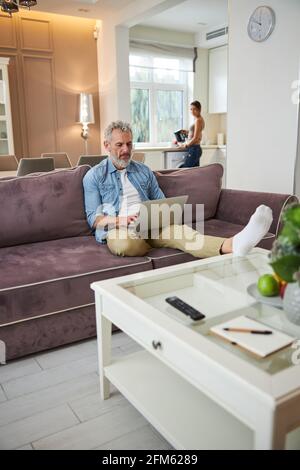 Homme barbu concentré en tapant la réponse sur le message Banque D'Images