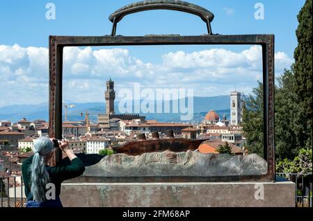 Femme prend une photo de la ville à travers une sculpture de Jean-Michel Folon au Giardino delle Rose. Vue imprenable sur la ville. Banque D'Images
