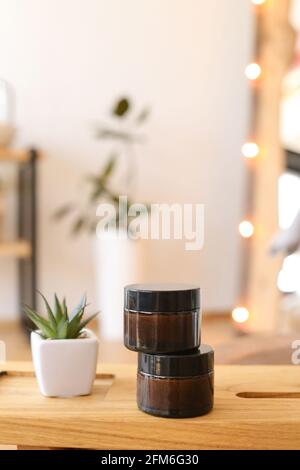 Cosmétiques pour les cheveux dans le pot en verre ambré arrière-plan neutre Banque D'Images