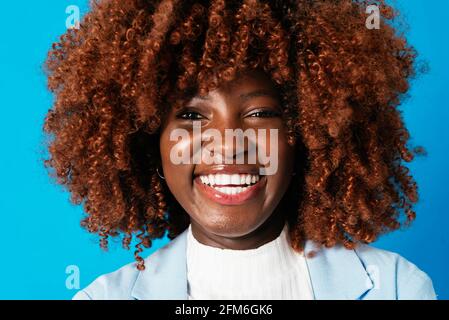 Portrait d'une belle femme d'affaires noire sur fond bleu Banque D'Images