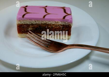 Éponge douce à gâteau Tipsy, imbibée de confiture de framboises savoureuse et débordant d'une saveur de rhum riche, Banque D'Images