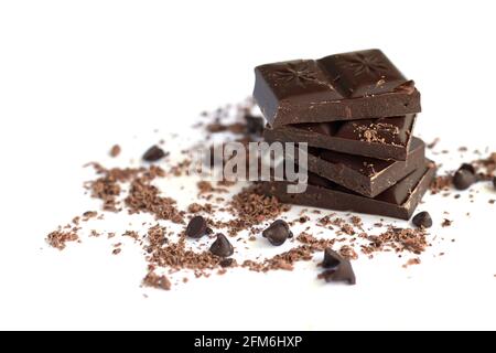 Pile de chocolat noir avec flocons de chocolat, poudre et gouttes isolées sur fond blanc Banque D'Images