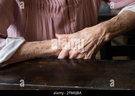 Une paire de femmes âgées les mains de grand-mère se replient et se couchés l'une sur l'autre. Banque D'Images