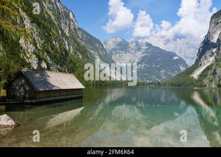 Vue panoramique de la traditionnelle maison de bateau en bois sur le lac Obersee et les montagnes dans le pays de Berchtesgadener, Bavière, Allemagne. Banque D'Images