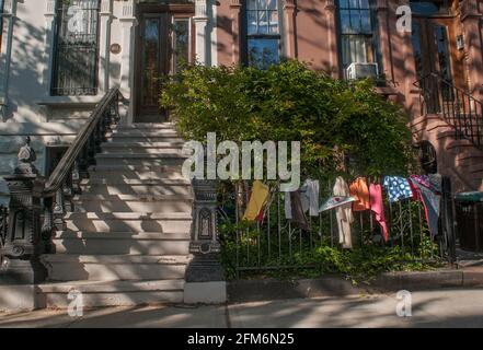 Des vêtements accrochés à une clôture noire en fer forgé sur President Street dans le quartier de Park Slope à Brooklyn, New York. Banque D'Images