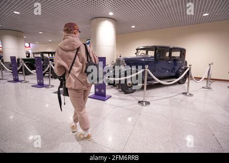 MOSCOU, RUSSIE - 3 MAI 2021 : femme prenant des photos d'une voiture rétro lors d'une exposition à l'aéroport de domodedovo Banque D'Images