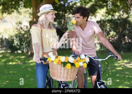 joyeux jeune couple à vélo le long de la route en été Banque D'Images