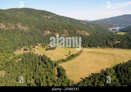 Photographie aérienne d'une ferme dans la baie de Gênes avec Birds Eye Cove en arrière-plan, île de Vancouver, Colombie-Britannique, Canada. Banque D'Images